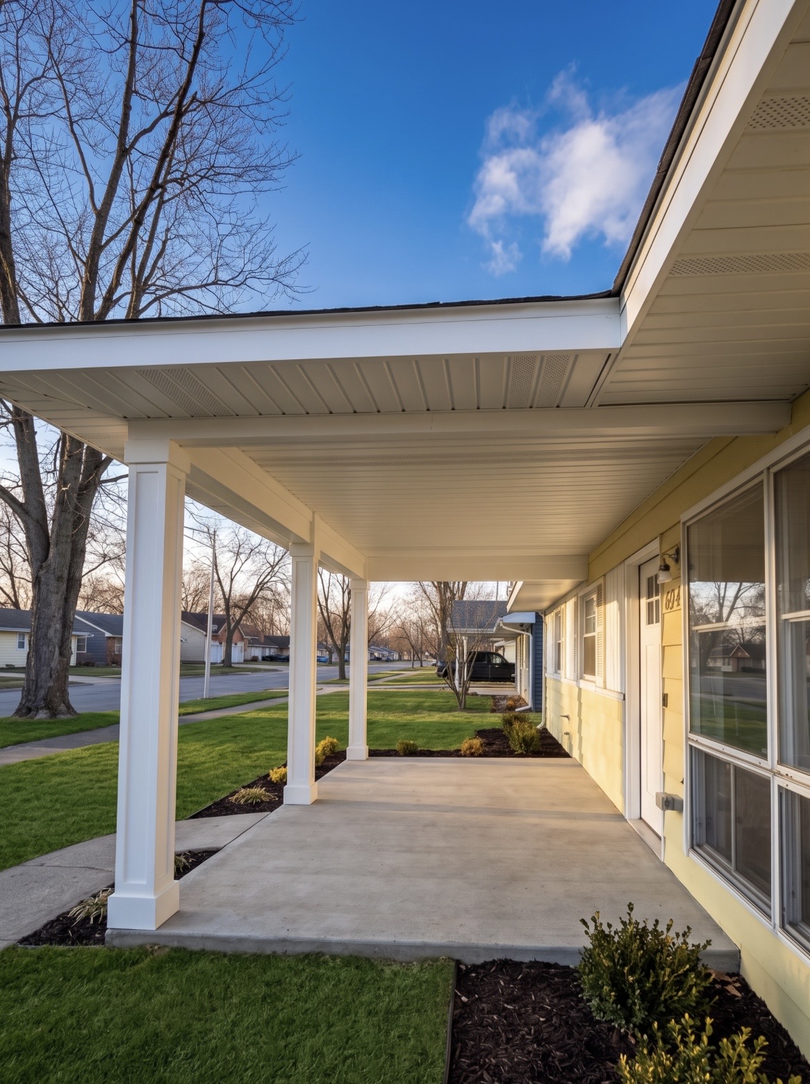 Covered front porch with columns and new concrete slab